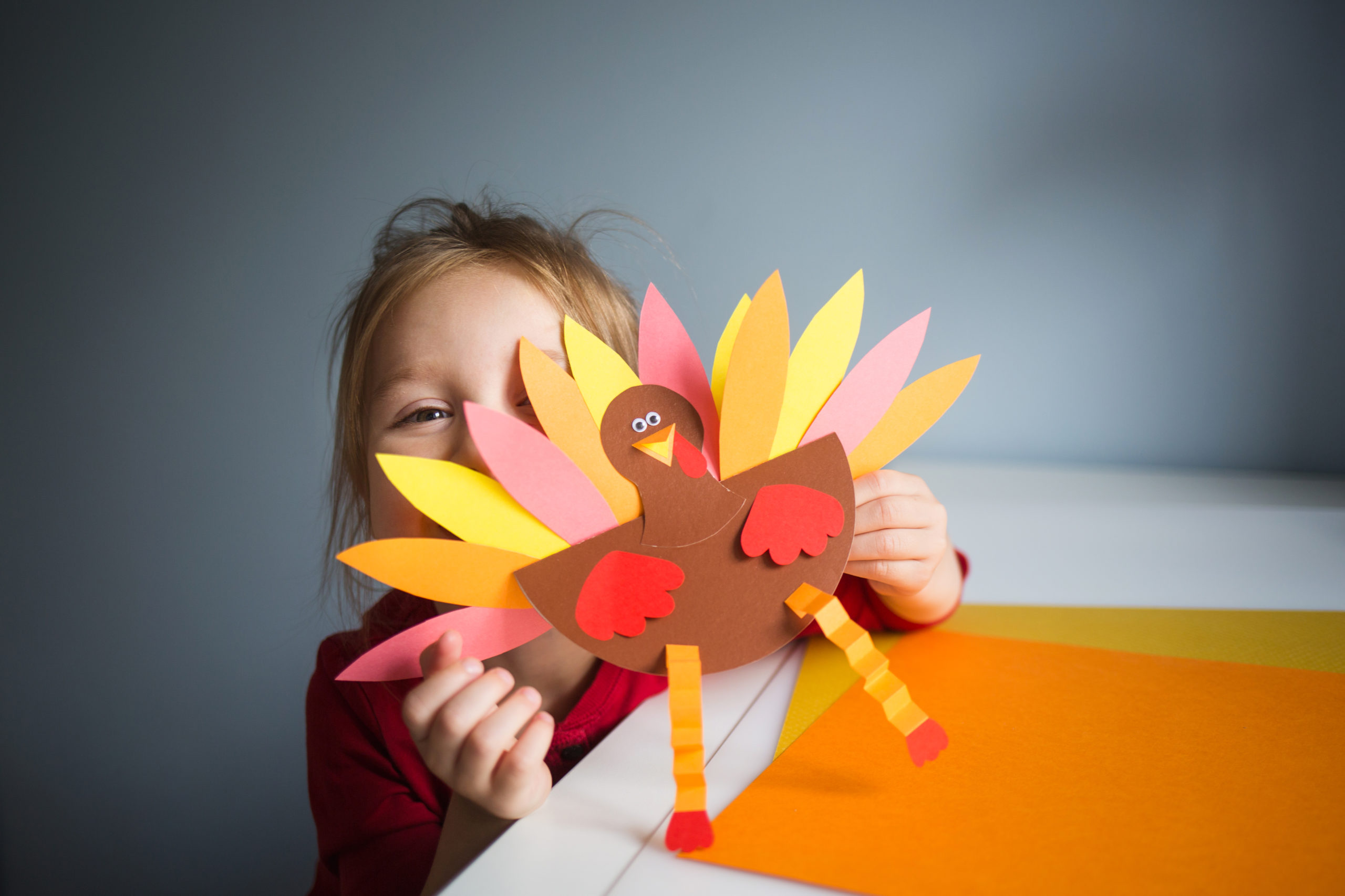 paper craft for kids. DIY Turkey made for thanksgiving day. create art for children. girl playing with a toy