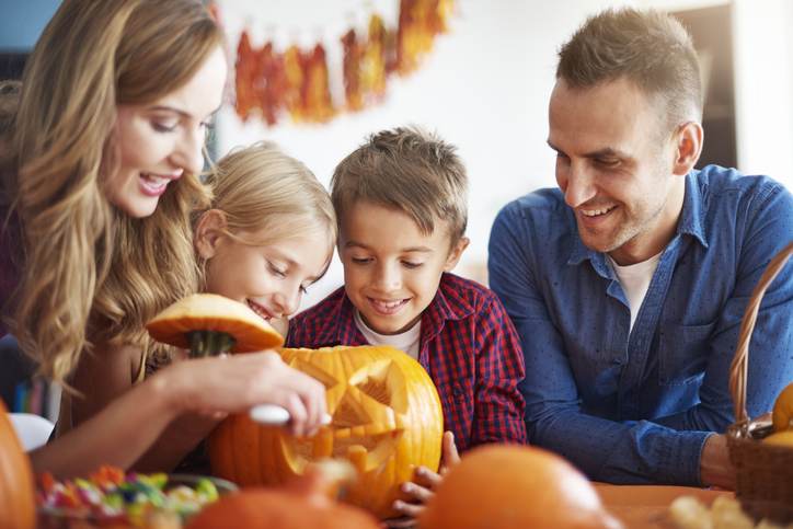 Parents helping children in carving pumpkins Parents helping children in carving pumpkins