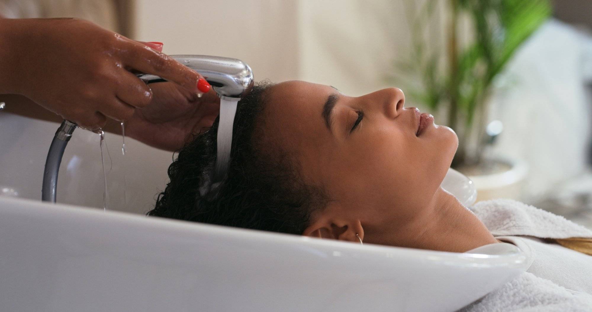 Shot of a young woman getting her hair washed at a salon Shot of a young woman getting her hair washed at a salon